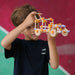 Child holding a Beaver wooden toy structure against a colorful background