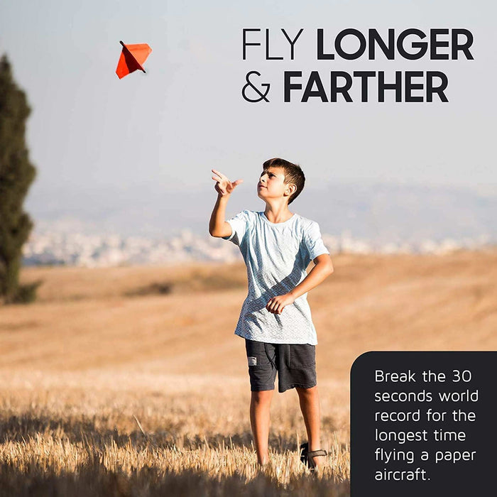 Person flying a Power Up paper airplane in an open field with promotional text overlay.