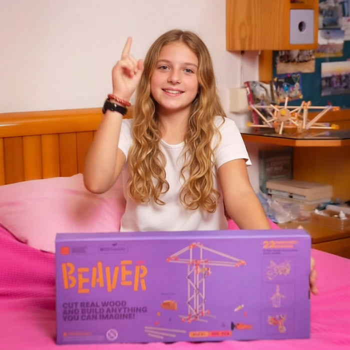 Young girl with a purple 'Beaver' wooden toy packaging in front of her.