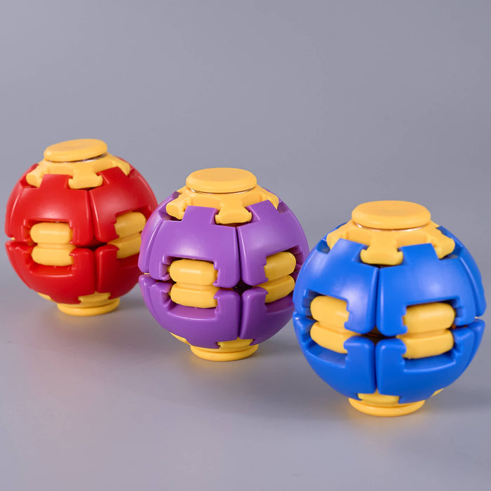 Three spherical puzzle balls in red, purple, and blue with yellow interlocking details, arranged on a smooth gray surface. Fidgit Sphere Spinner