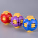 Three spherical puzzle balls in red, purple, and blue with yellow interlocking details, arranged on a smooth gray surface. Fidgit Sphere Spinner
