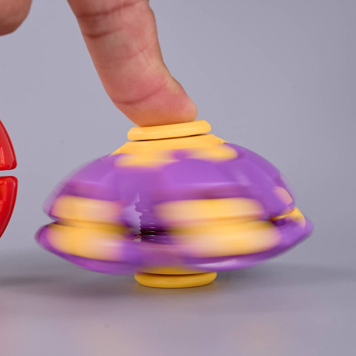 A purple and yellow plastic toy gyroscope spinner being spun by a human finger, shown against a neutral gray background. Fidgit Sphere Spinner
