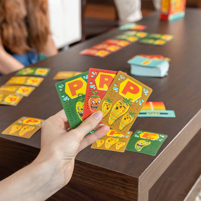 Hand holding colorful game cards with cartoon characters on a wooden table