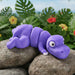Purple rubber ducky on a rock with a tropical background from heebie jeebies