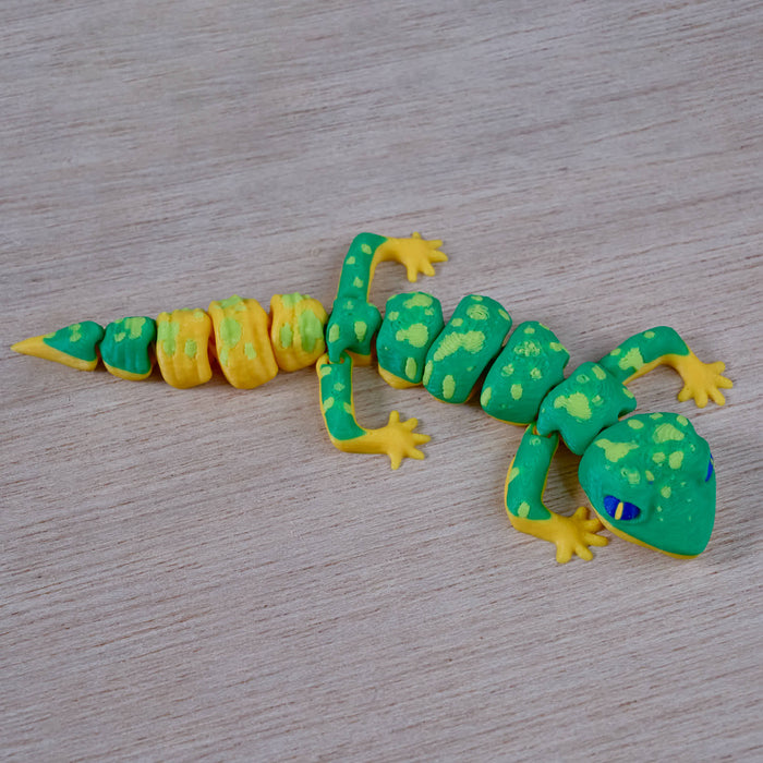 Toy Heebie Jeebies 3D Gecko with green and yellow pattern on a wooden surface