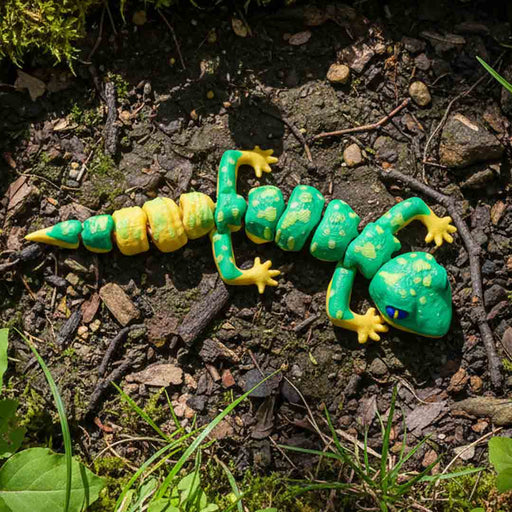 Heebie Jeebies 3D Toy lizard on a natural ground surface with grass and leaves
