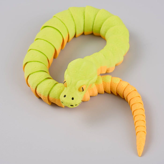 Heebie Jeebies 3D toy snake with green body and orange head and tail on a light gray background