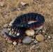 Black and red snake-like toy on stones with a natural background