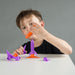Child playing with toy rocket from heebie Jeebies on a gray background