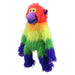 A colorful rainbow monkey plush toy sits on a child's bed with a light blue duvet cover and white floral bedding in a bright, modern bedroom.