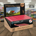 Display box of PowerUp 2.0 Electric Paper Airplane Kit on a wooden surface with a blurred store background.